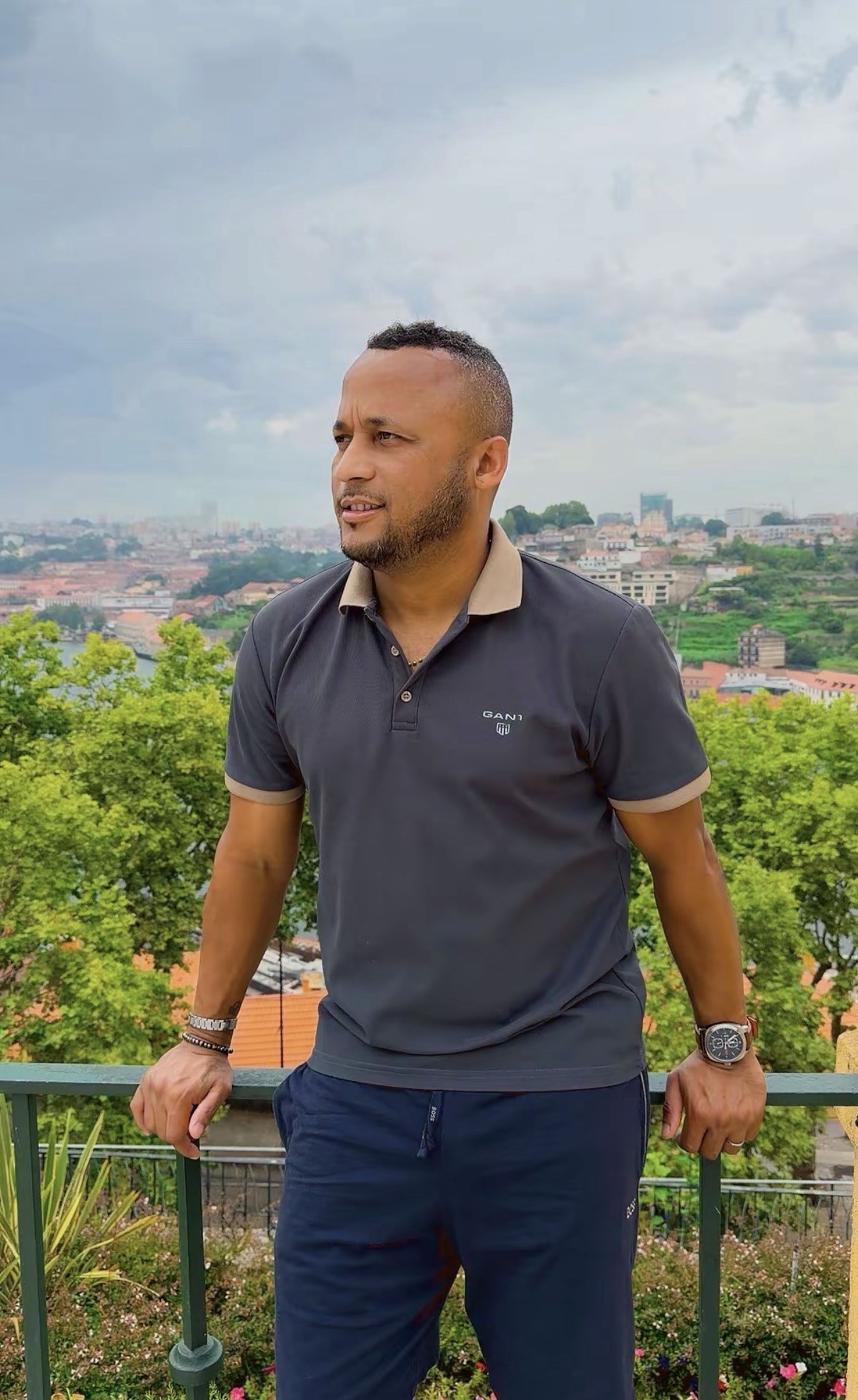 Jaylson Spencer ao ar livre, com uma cidade ao fundo