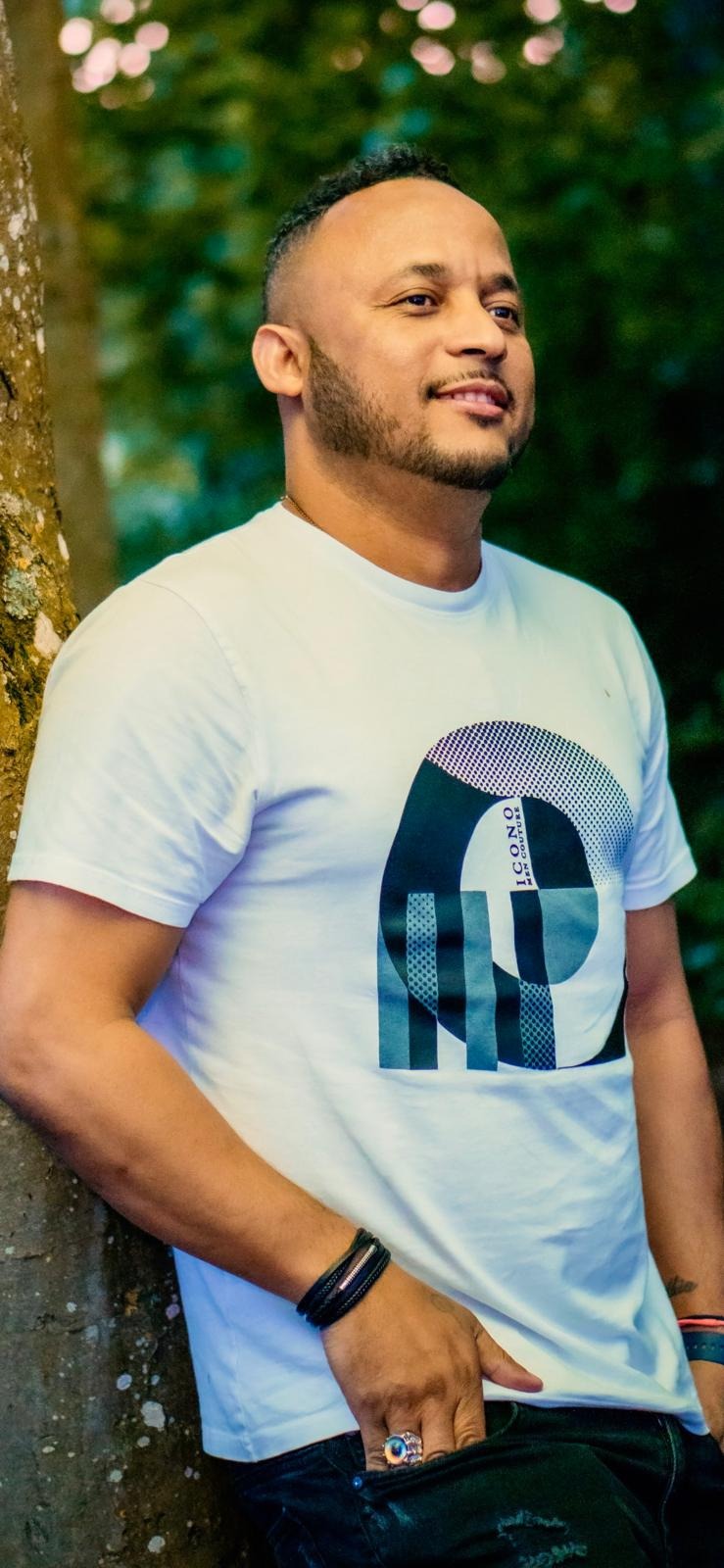 Jaylson Spencer ao ar livre, junto a uma árvore